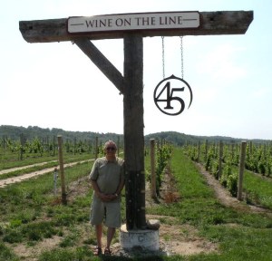 Me leaning on vineyard marker at 45 North Vineyard and Winery near Suttons Bay.